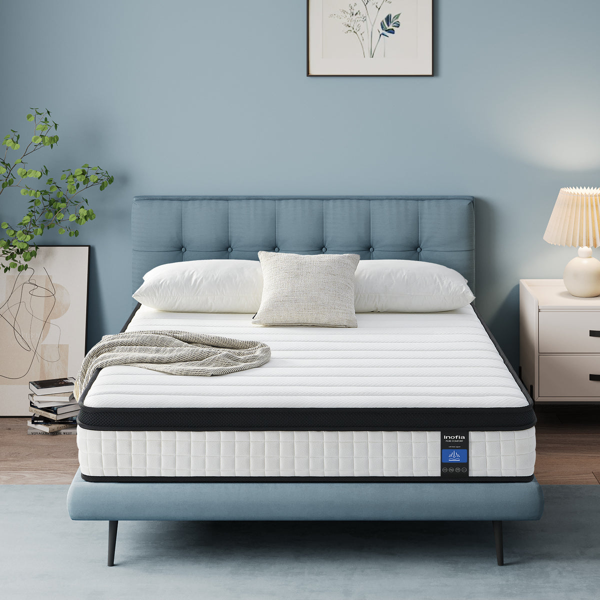 Mattress on a bed in a bedroom setting with a blue wall and decorative elements. The queen mattress size offers the perfect balance of space, comfort, and support for most bedrooms.
